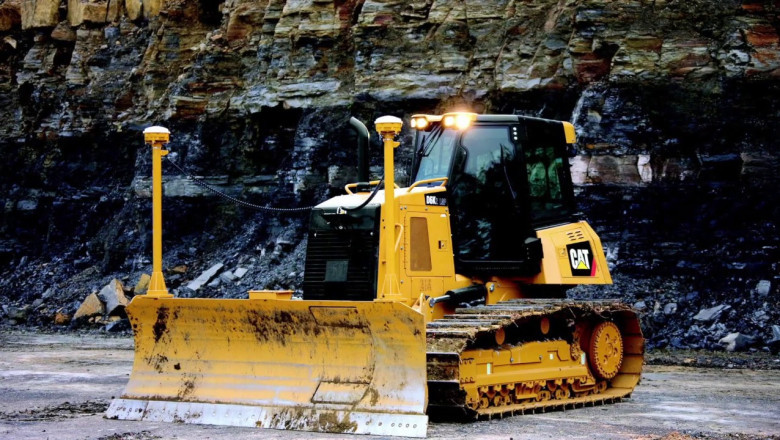 It is a large motorized machine with a metal blade that pushes material during construction